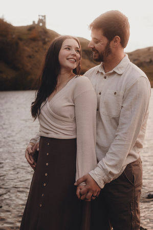 Romantic couple portrait at sunset in Holyrood Park, Edinburgh, cinematic style, natural light, capturing genuine connection and fine art storytelling