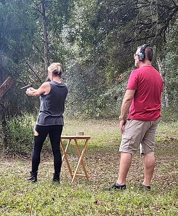 Two people shooting guns during our life fire portion of the new york state concealed carry class with license.