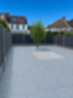 Modern paved patio with a central tree to explore the work of our projects.