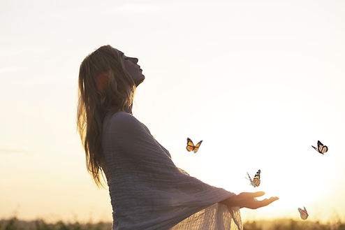 surreal encounter between a woman and free butterflies flying in the middle of nature.