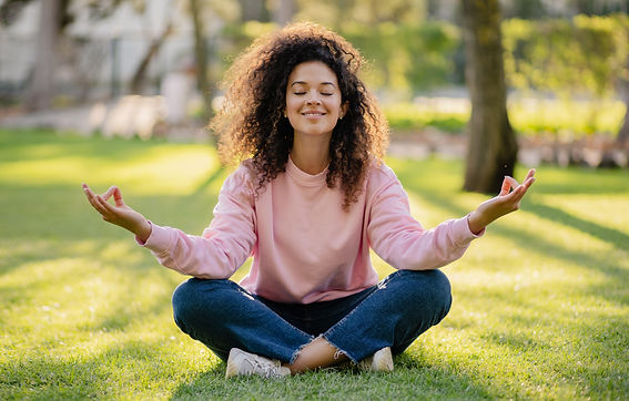 pretty young curly woman making digital detox in park meditating, having peace time for tr