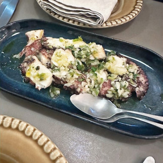 grilled octopus on a black plate
