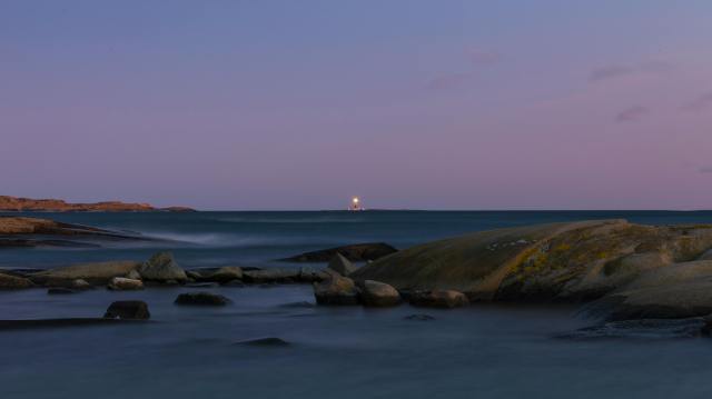 photo of body of water with boulders