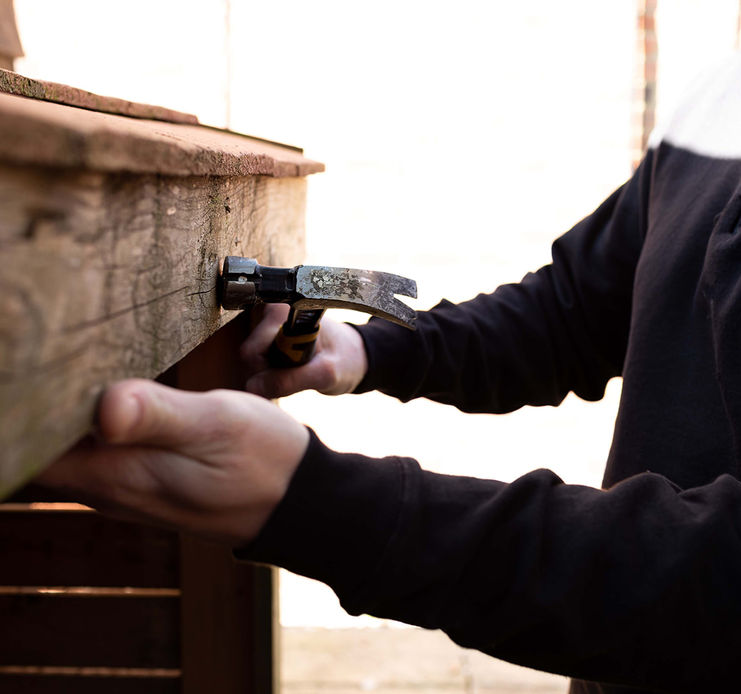 Elegon Property Solutions Northants employee using a hammer on wood