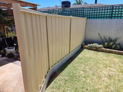 Side privacy fence in classic cream with concrete plain grey concrete plinths.