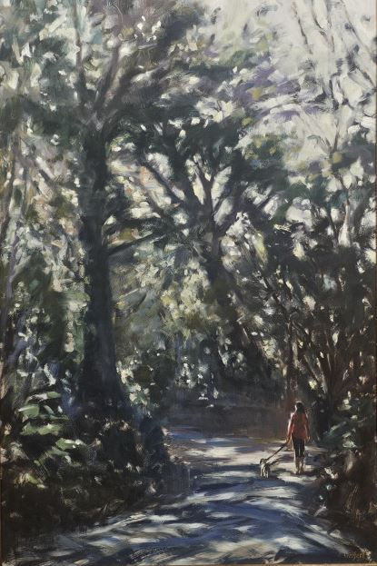 A girl walking through the woods with her dog