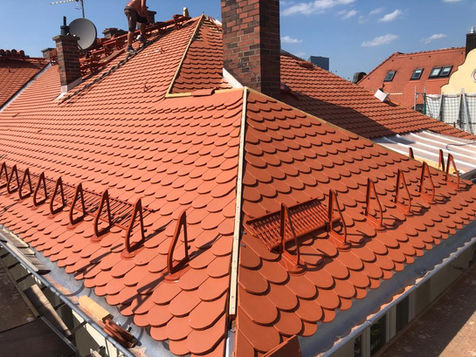 Dachdecker bei der Arbeit an roten Ziegeln