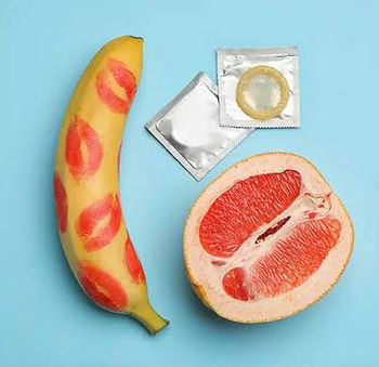 Banana, laranja e preservativo em imagem sexualmente sugestiva