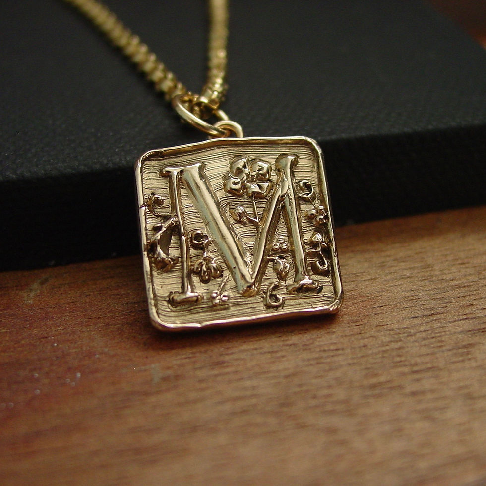 Letter M initial necklace on canvas