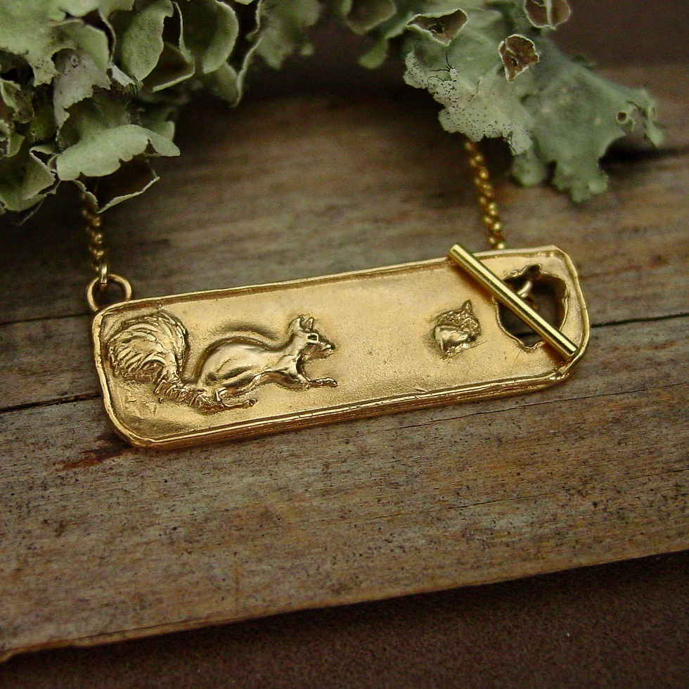 Thumbnail: Squirrel necklace next to green moss