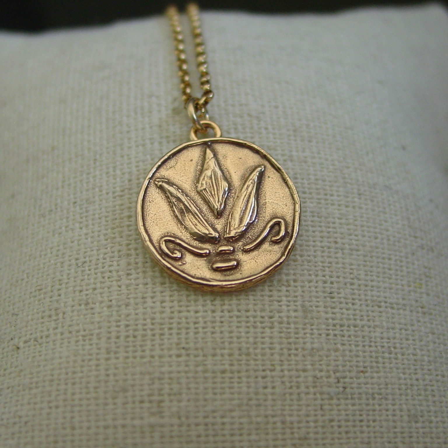 Greek lotus necklace on linen