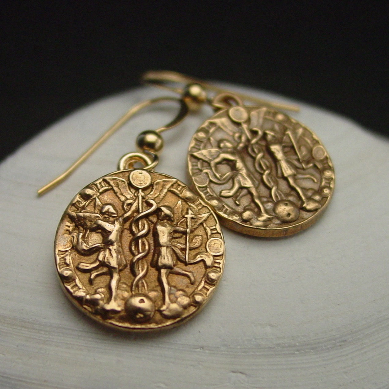 Gemini coin earrings on shell