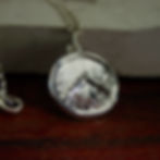 Small silver Spartan shield necklace close up sideway