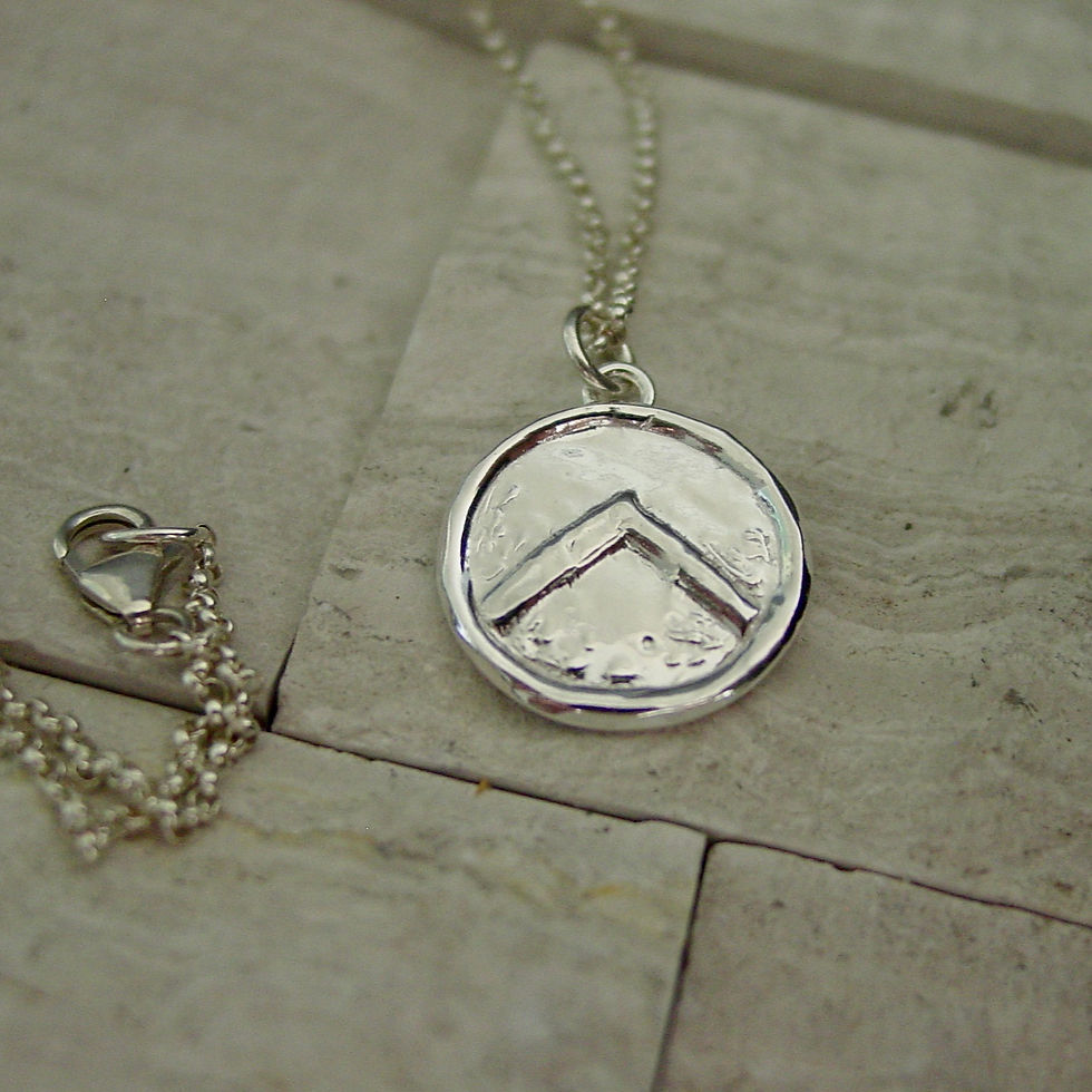 Thumbnail: Small silver Spartan shield necklace on limestone