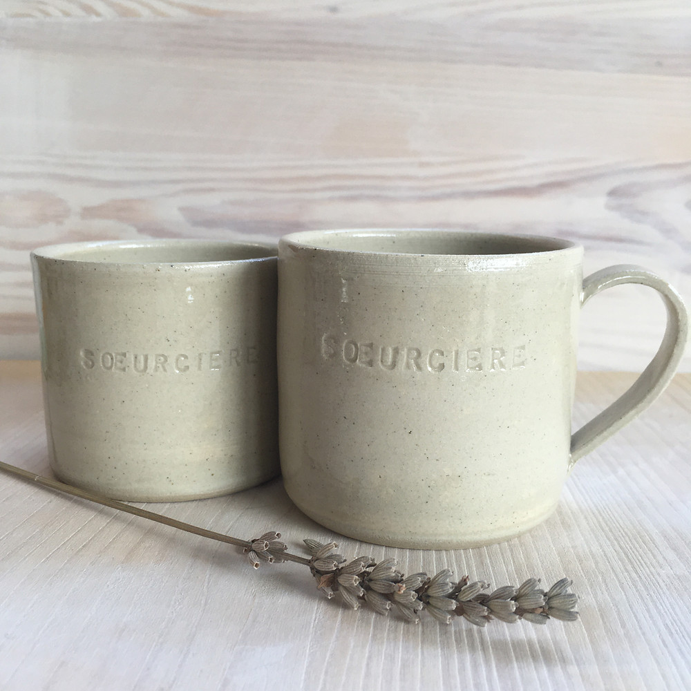 Une tasse et un mug en céramique couleur sable gravé Soeurcière, avec un brin de lavande