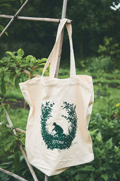 Illustrated tote bag in a natural setting for the young people's charity Grow. The tote bag is illustrated with an image of a person gardening, surrounded by plants