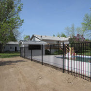 A picture showing wrought iron fencing and a pool