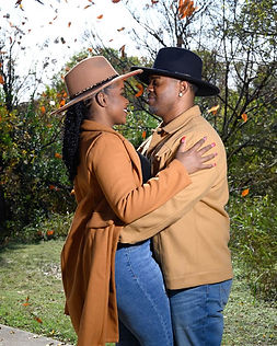 Couple wearing cowboy hats standing close together during an outdoor portrait session