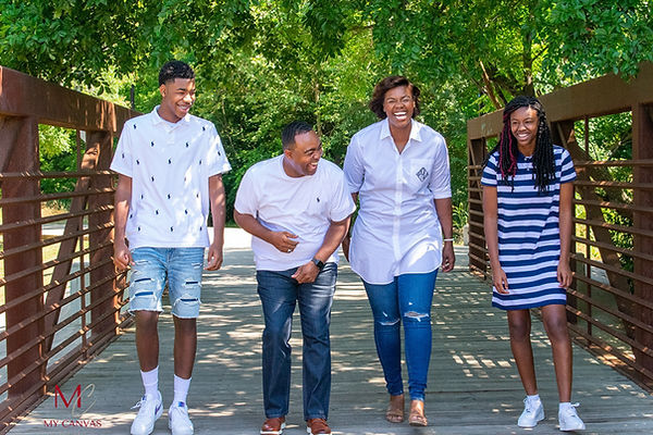 Family of four laughing and walking together during an outdoor family photography session in Central Texas.
