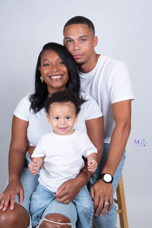 Studio portrait of parents and their toddler during a family photoshoot in Austin TX, featuring clean backgrounds and natural expressions.
