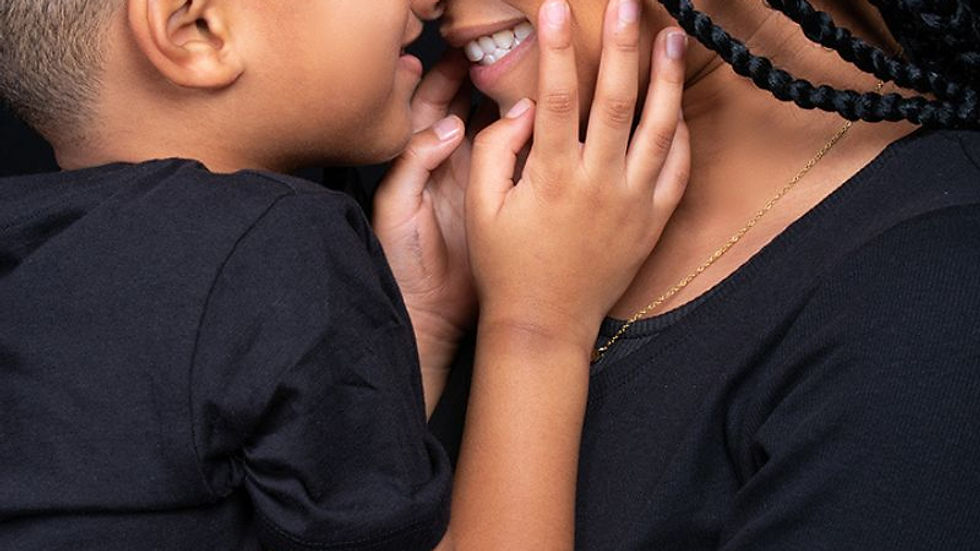 Mother and child touching foreheads during a family photoshoot in Austin TX, captured in a close-up portrait emphasizing love, trust, and connection.