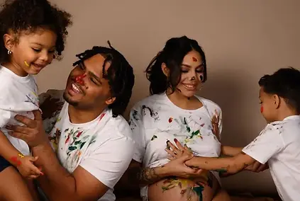 A joyful family enjoys a playful maternity session covered in colorful paint, laughing together as they celebrate new life. The expecting mother smiles as her children paint her belly, turning the photoshoot into a fun and heartfelt memory. Captured by My Canvas Portraits, a creative maternity photographer in Killeen, TX, this image highlights the joy and personality of family-centered maternity photography. It’s full of life, laughter, and genuine connection — a perfect blend of emotion and creativity.