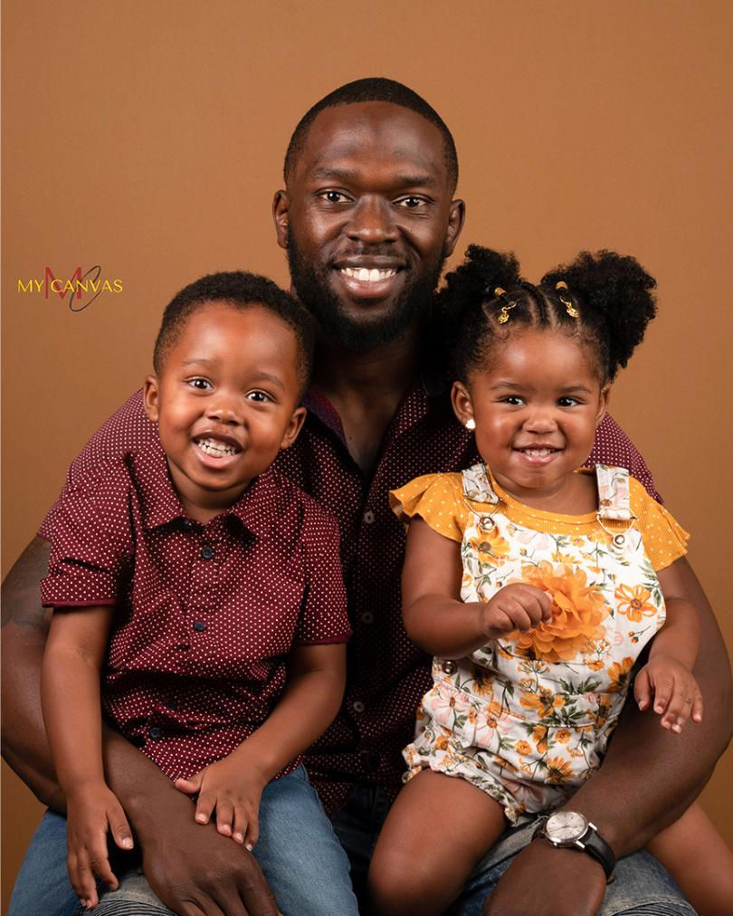 Father sitting with his young son and daughter during a studio family portrait