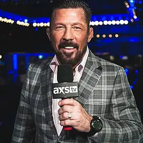 Pat Miletich holding an AXS TV microphone in a checkered suit.