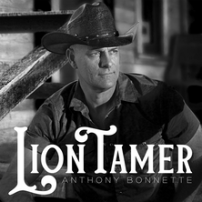 Anthony Bonnette "Lion Tamer" single cover – black-and-white portrait of Anthony in a cowboy hat and button-up shirt on rustic wooden stairs, with bold white title text.
