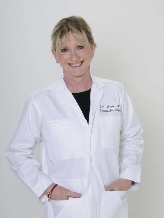 Dr. Lee Merritt, orthopedic surgeon and featured speaker at the Sovereign Health Summit 2026, smiling in a white medical coat.