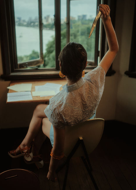 Cotton Organdy hand-embroidered button-down blouse in sky blue, with Wool-Cashmere hand-dyed bralette and shorts. Complete with lasercut timber, cotton, and leather handbag, timber and leather Apostrophe sandals, and  cast chrome letter opener.