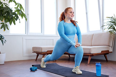 overweight freckled woman doing stretching exercise at home, on fitness mat. attractive ca