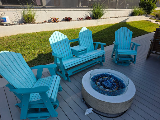 Teal HDPE Adirondack chairs and glider bench around an outdoor fire pit