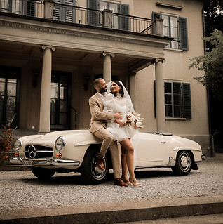 Brautpaar sitzt auf weissem Oldtimer vor eleganter Hochzeitsvilla in Zürich – Gartenhochzeit mit Stil