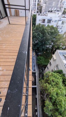 דק במבוק סינטטי מותקן במרפסת עם נוף אורבני בבניין משופץ ברחוב פרופסור שור בתל אביב, עבודה של צוות המקצוענים בהתקנת דק עץ של WOOD PRO