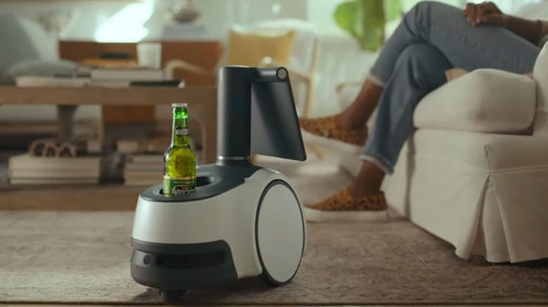 Miniature : Astro robot with a beer bottle delivering drink, relaxing person in background.