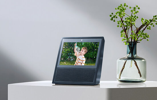 الصورة المصغرة: Smart display shows a child playing with bubbles, next to a vase.
