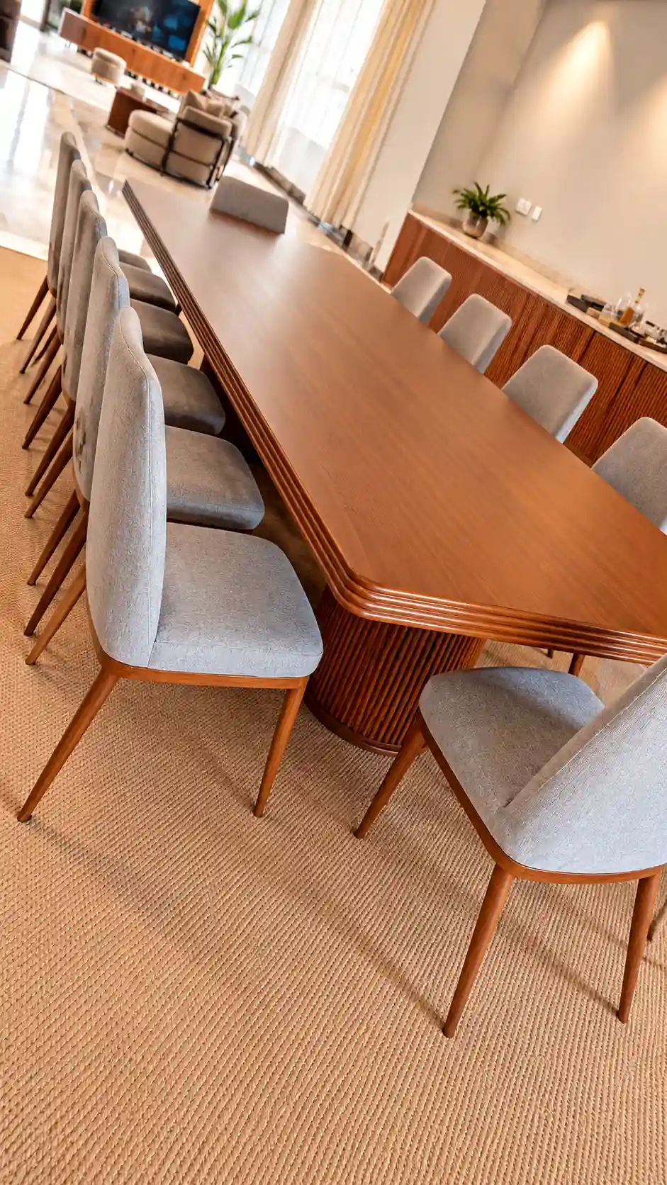 Large luxury custom-made wooden dining table featuring a premium timber grain finish and a heavy fluted wood architectural pedestal support column.