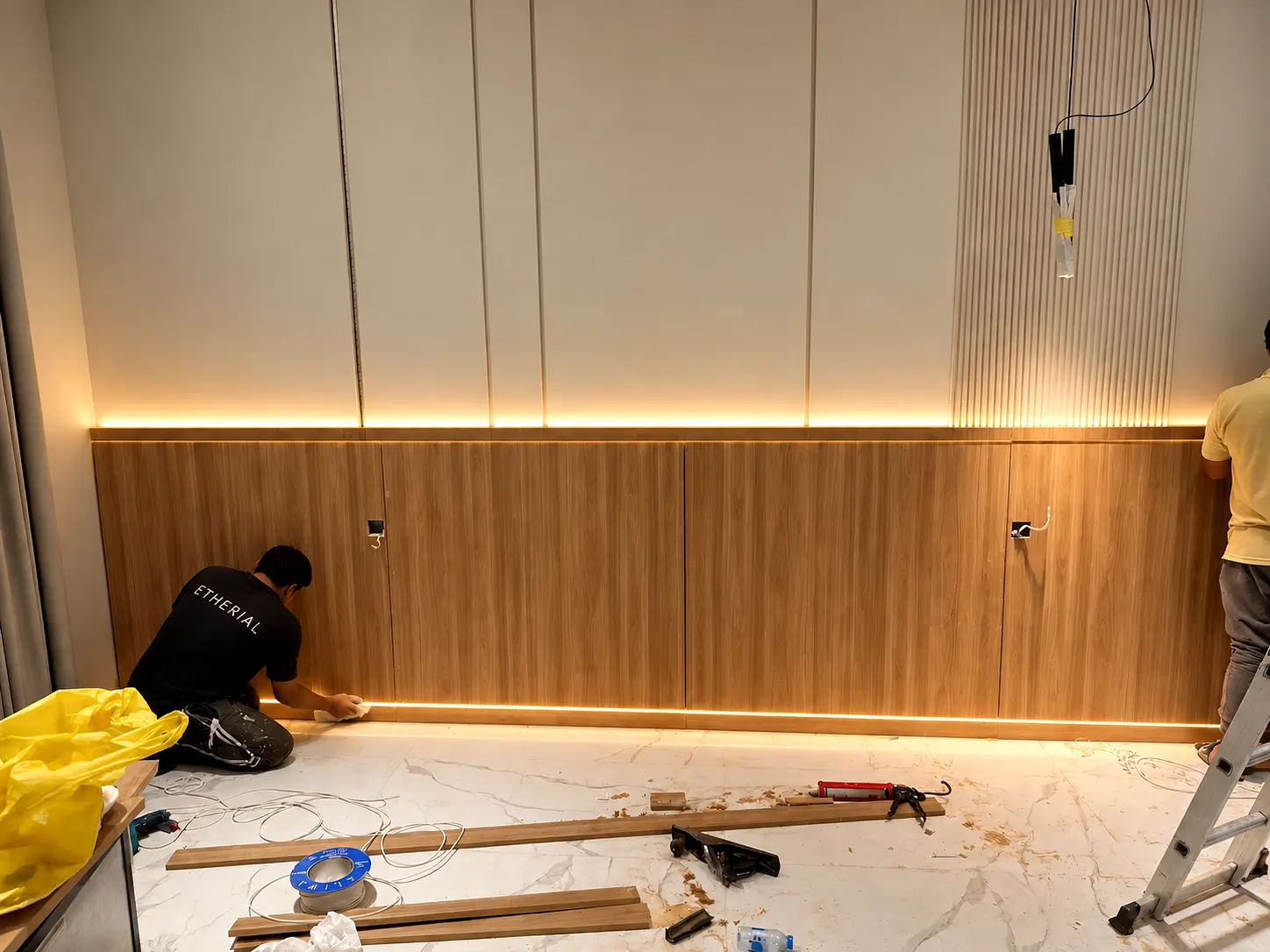 Joinery installation in progress with timber wall panels and recessed warm lighting.