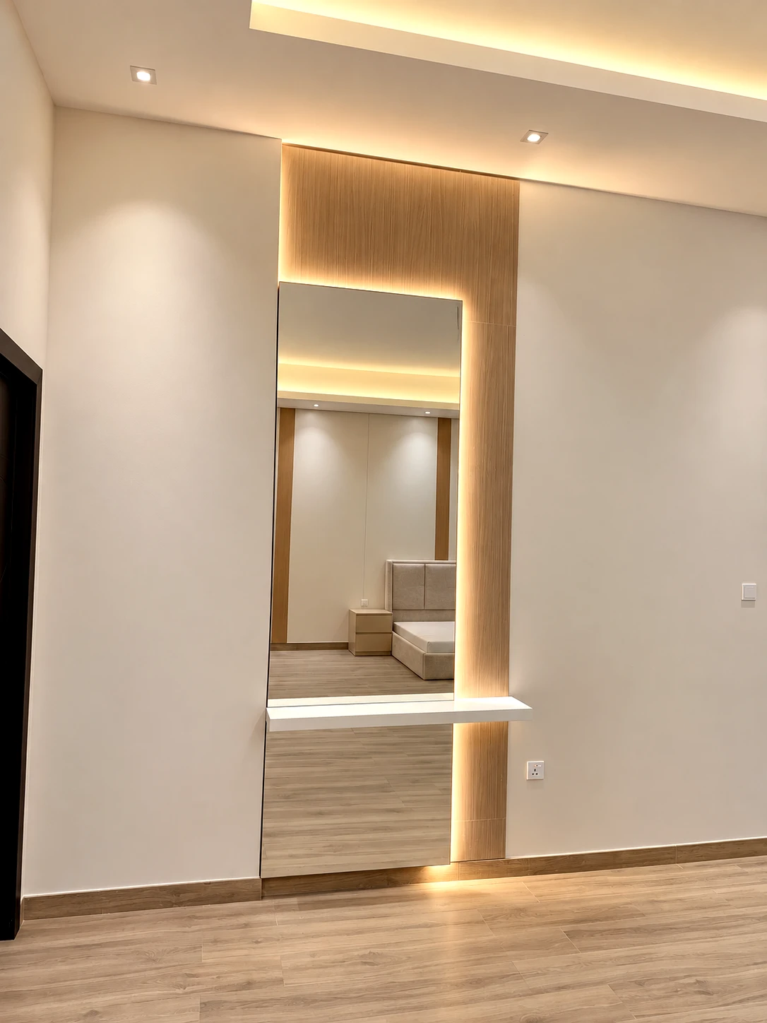 Minimal dressing unit with rectangular backlit mirror and fitted drawers.