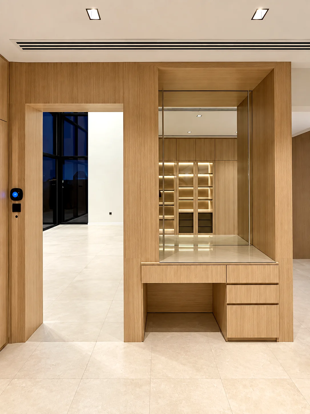 Fitted timber dressing table with drawers and mirror integrated beside a bedroom doorway.