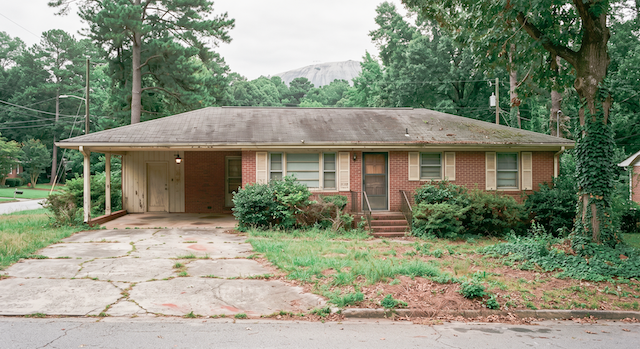 1 documentary style photograph of the aging 1960s brick ranch in DeKalb County Georgia It 