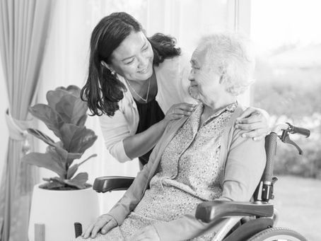 Woman smiling at senior woman in wheelchair