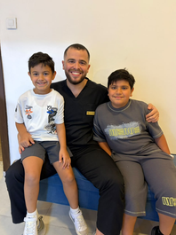 Dr. Adnan Alakhras with young patients after a successful dental appointment in Amman