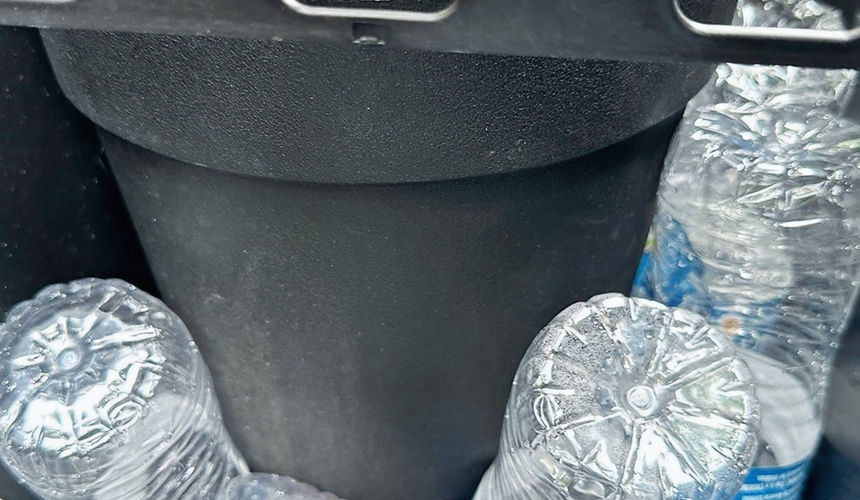 Empty water bottles are used to secure the faux plants in the large planters.