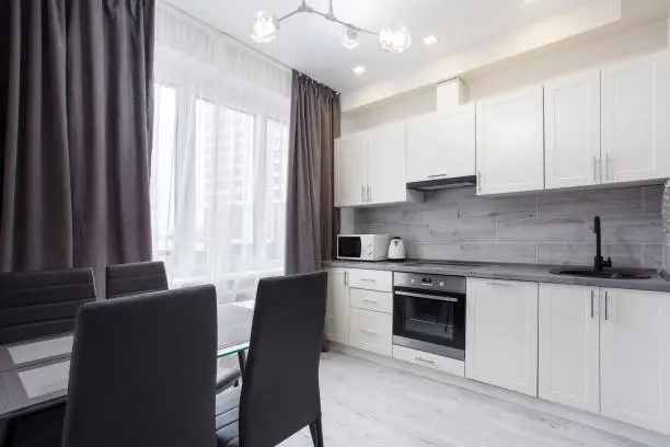 Modern New Zealand kitchen showing common chattels like oven, microwave, and dining set