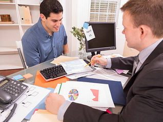 Property investment accountant reviewing financial reports with a client.
