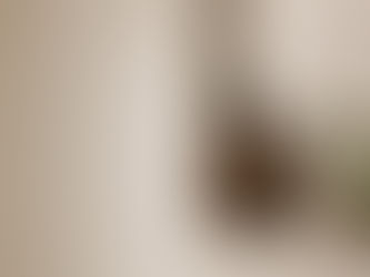 Douche minimaliste avec peigne à dents larges et démêlant, illustrant le démêlage des cheveux bouclés sous la douche.