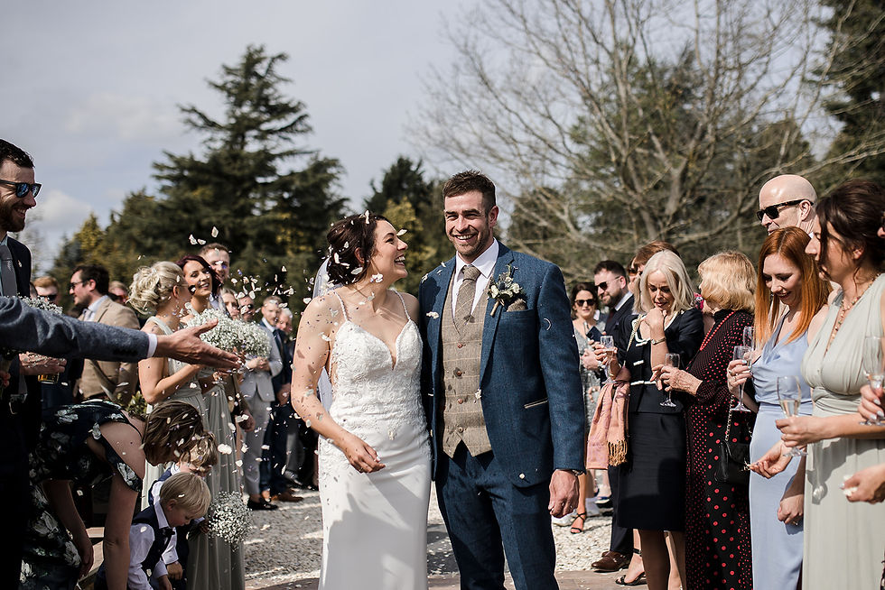 The couple exiting up confetti at Woodstock Weddings Venue