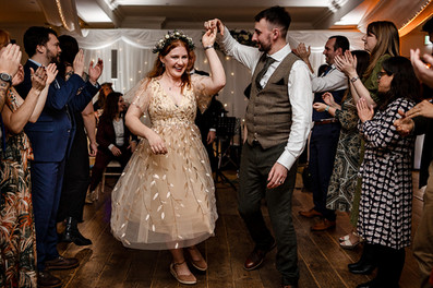 Candid wedding photo of bride and groom ceilidh dancing during North Yorkshire wedding reception